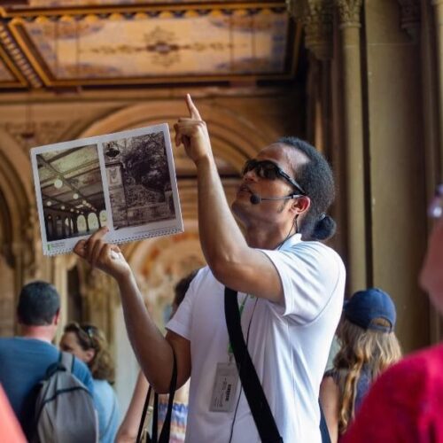 A tour guide pointing to the Minton Tiles under the Bethesda Arcade.