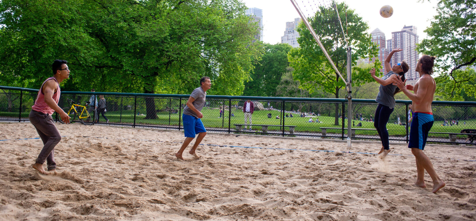 Four players squaring off on the volleyball court