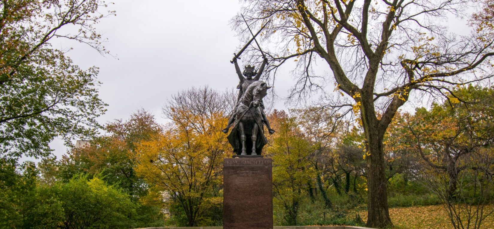 The King is seen astride his horse and holding two swords in his upraised hands