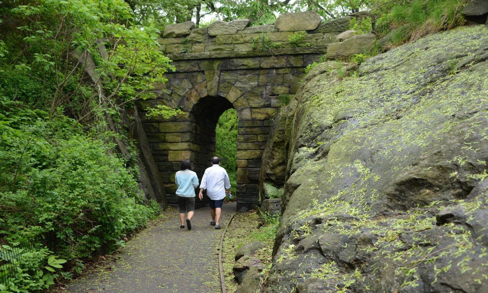 A couple about to walk through the arch in summer